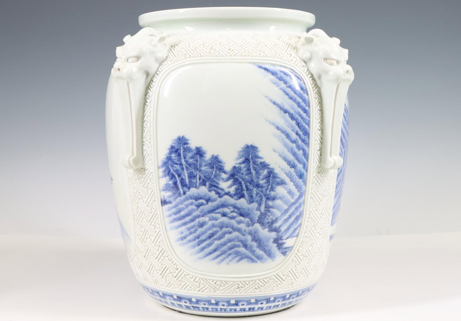 Japanese Hirado Porcelain Vase: Meiji era vase, blue and white landscape decoration with applied dragon mask handles and incised geometric motif, marked. A rim chip has been professionally restored. 9.5"h x 9.5"