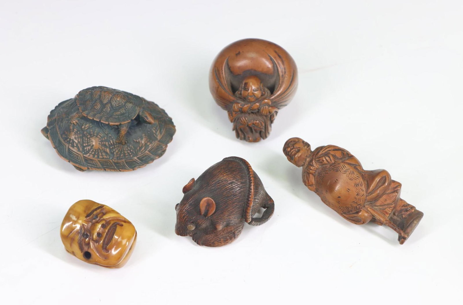 Collection of Wood Netsukes: Collection of 5 wood netsukes including; 1.) Small turtle on back of large turtle (missing reinforcement on cord hole. 2.) Mouse. 3.) Man with hat. 4.) Man with large sack on back. 5.) Bone netsuke wi
