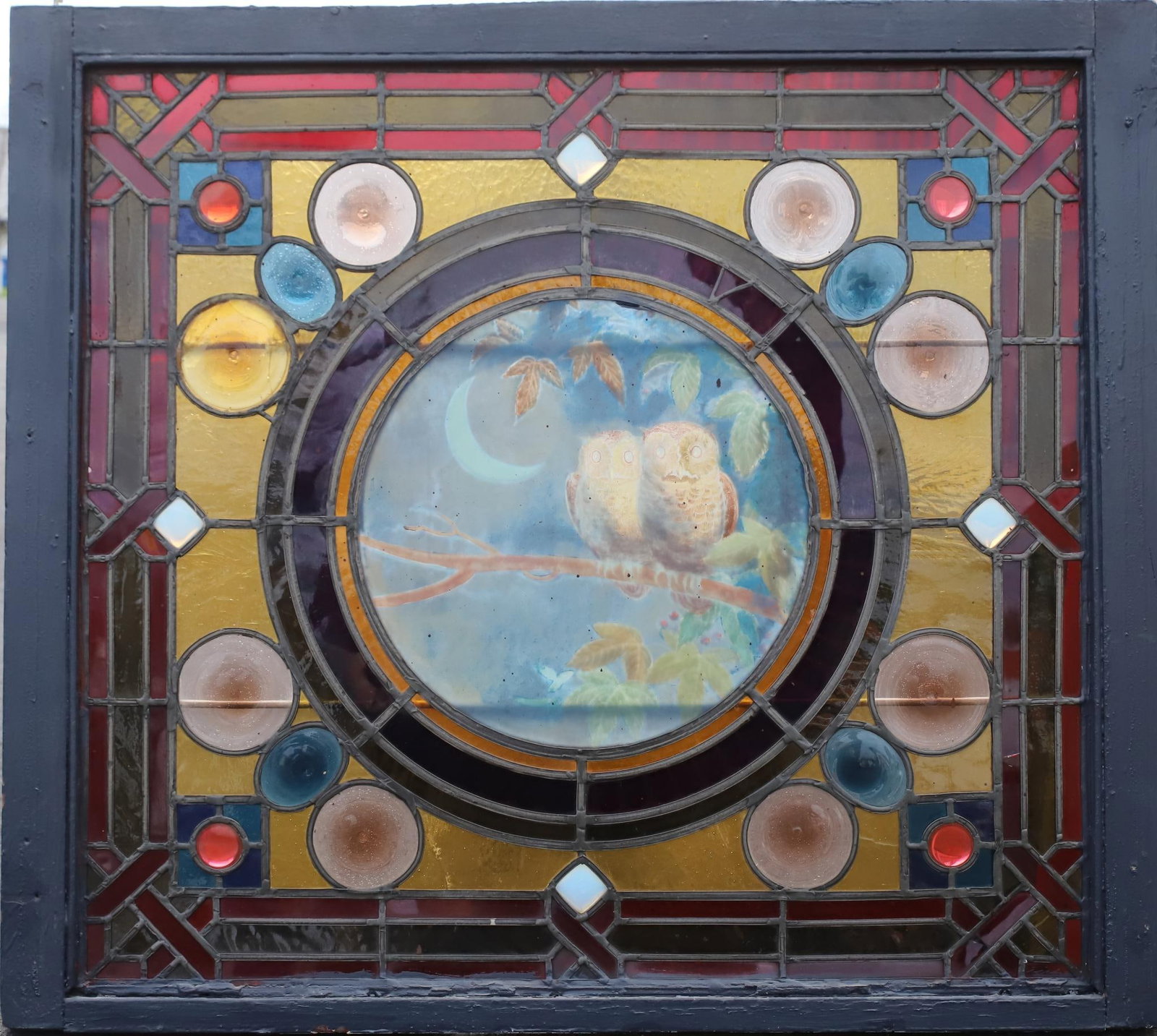 Stained Glass Window: Stained glass window with perched owls surrounded by geometric and woven designs. 30.5"h x 34.5"w