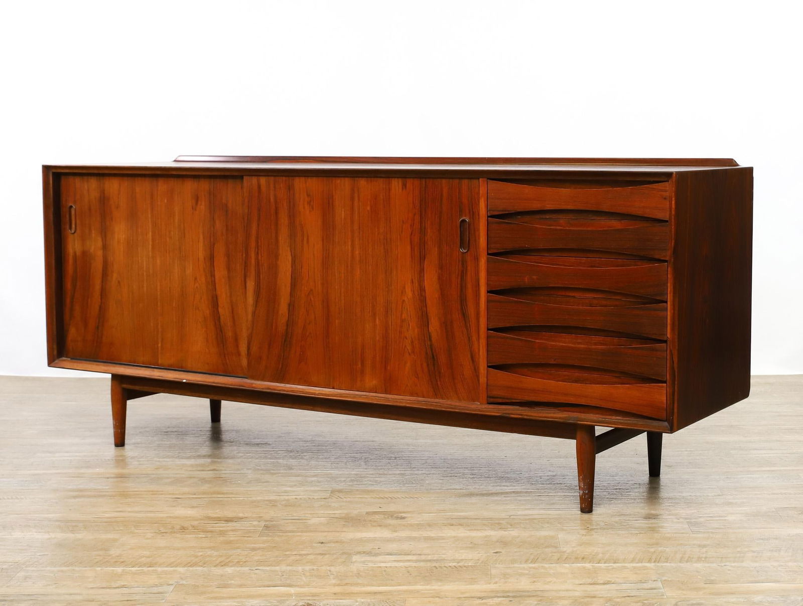 Arne Vodder for Sibast Model 29 Sideboard: Danish Modern rosewood sideboard with six drawers beside two cabinets with sliding doors which open to adjustable shelving, mounted to a base with cigar legs, labeled for Sibast and Danish Furniturema