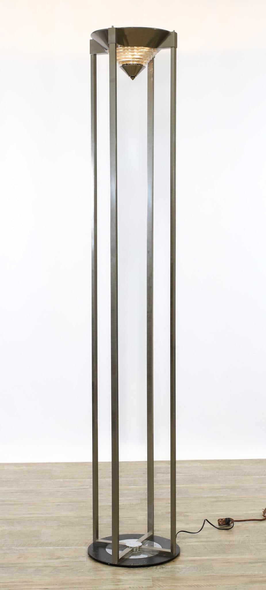 Robert Sonneman for Kovacs Torchiere Floor Lamps: Chrome torchiere floor lamp with a conical shade featuring ribbed glass, supported by four columns on a round base, unmarked. In working condition. 6'h x 13.5"w