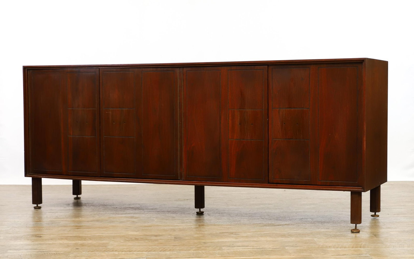 Walnut Sideboard: Sideboard with paneled doors which open to three cabinets with adjustable shelving, on straight square legs. Missing the pulls. Wear including water stains. 31.5" h x 75" w x 19" d