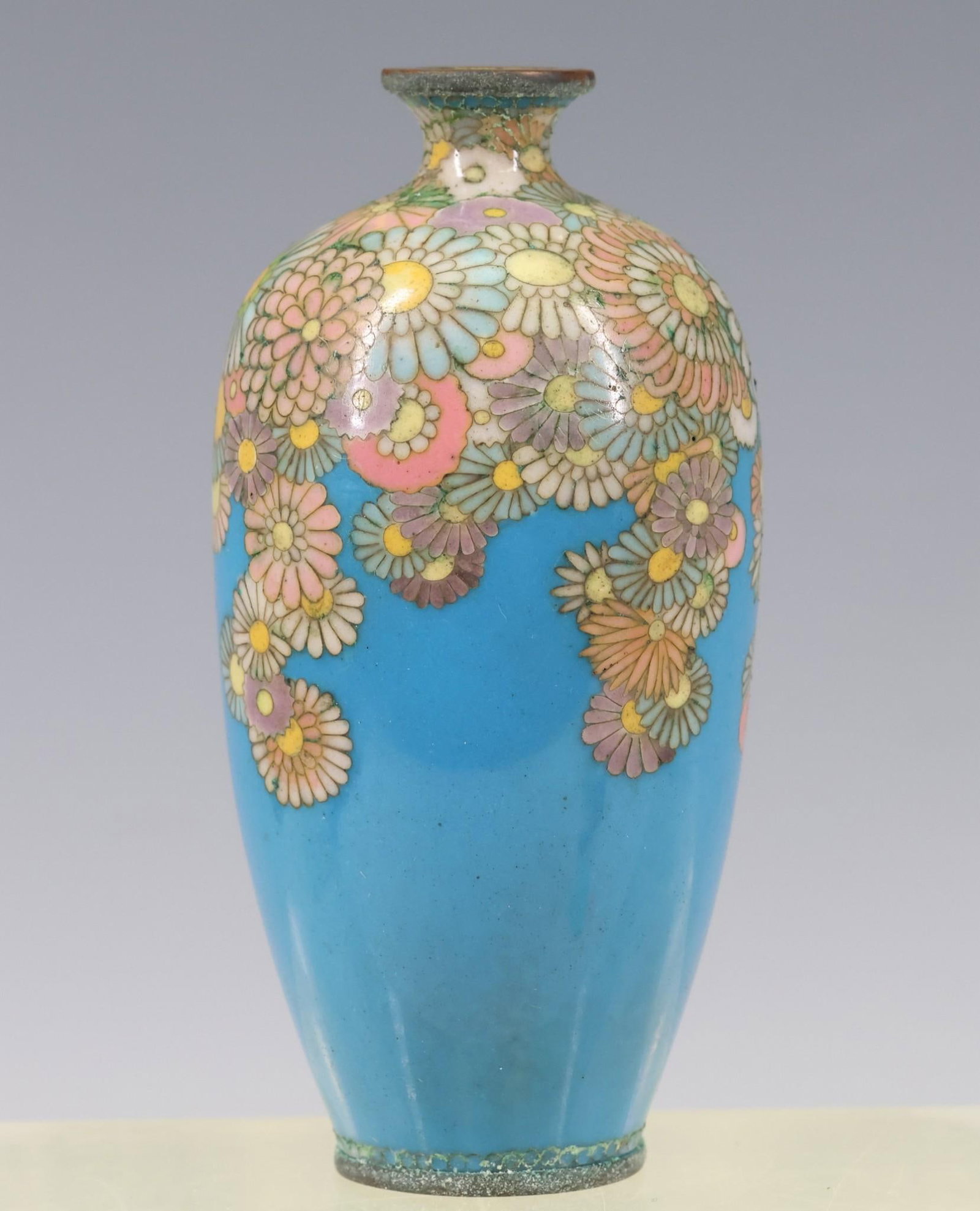 Japanese Cloisonne Vase: Meiji - Taisho era miniature vase decorated with flower balls on a sky blue ground. Mokugyo (temple bell) mark to the foot. Some corrosion to the metal. 3.5"h x 1.75"w