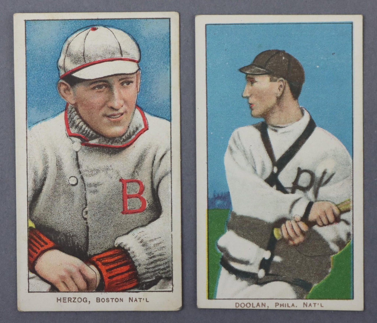 (2) 1909-11 T206 Piedmont Baseball Tobacco Cards: (2) 1909-11 T206 Piedmont White Border baseball tobacco cards: Mickey Doolan (batting variation) & Buck Herzog (Boston variation). The cards are free of creases & have good to very good centering. Bot