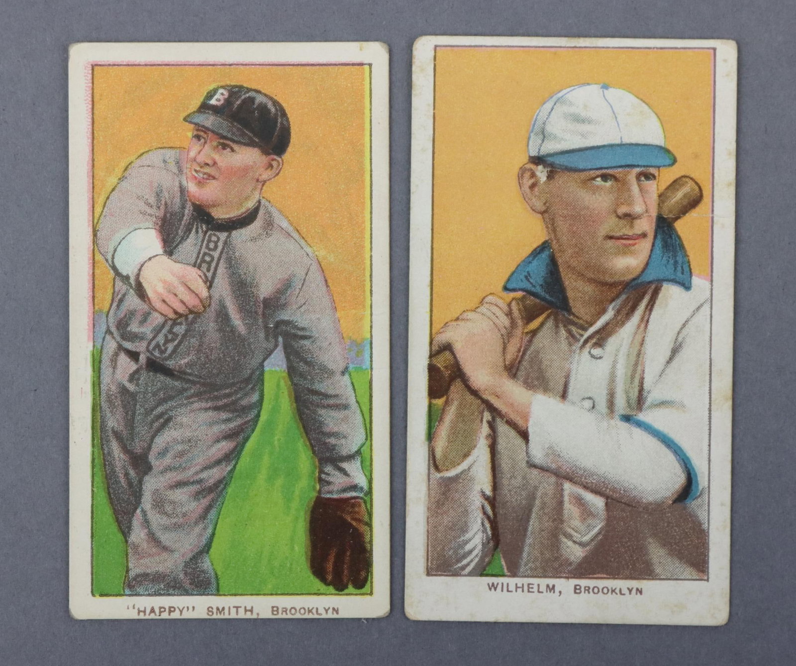 (2) 1909-11 T206 Sweet Caporal Baseball Tobacco Cards: (2) 1909-11 T206 Sweet Caporal White Border baseball tobacco cards: Happy Smith & Kaiser Wilhelm (with bat variation). Both cards have a light crease and the Smith card has writing on the back. They b