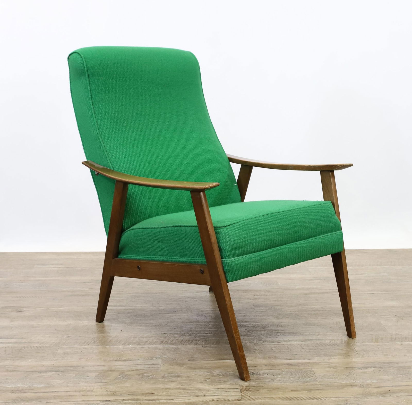 Danish Modern Style Lounge Chair: Teak high back lounge armchair with shaped arms, flared and tapered square legs, straight side stretchers, and kelly green upholstery. Made in Yugoslavia. One front leg is somewhat out of line. 37"h x