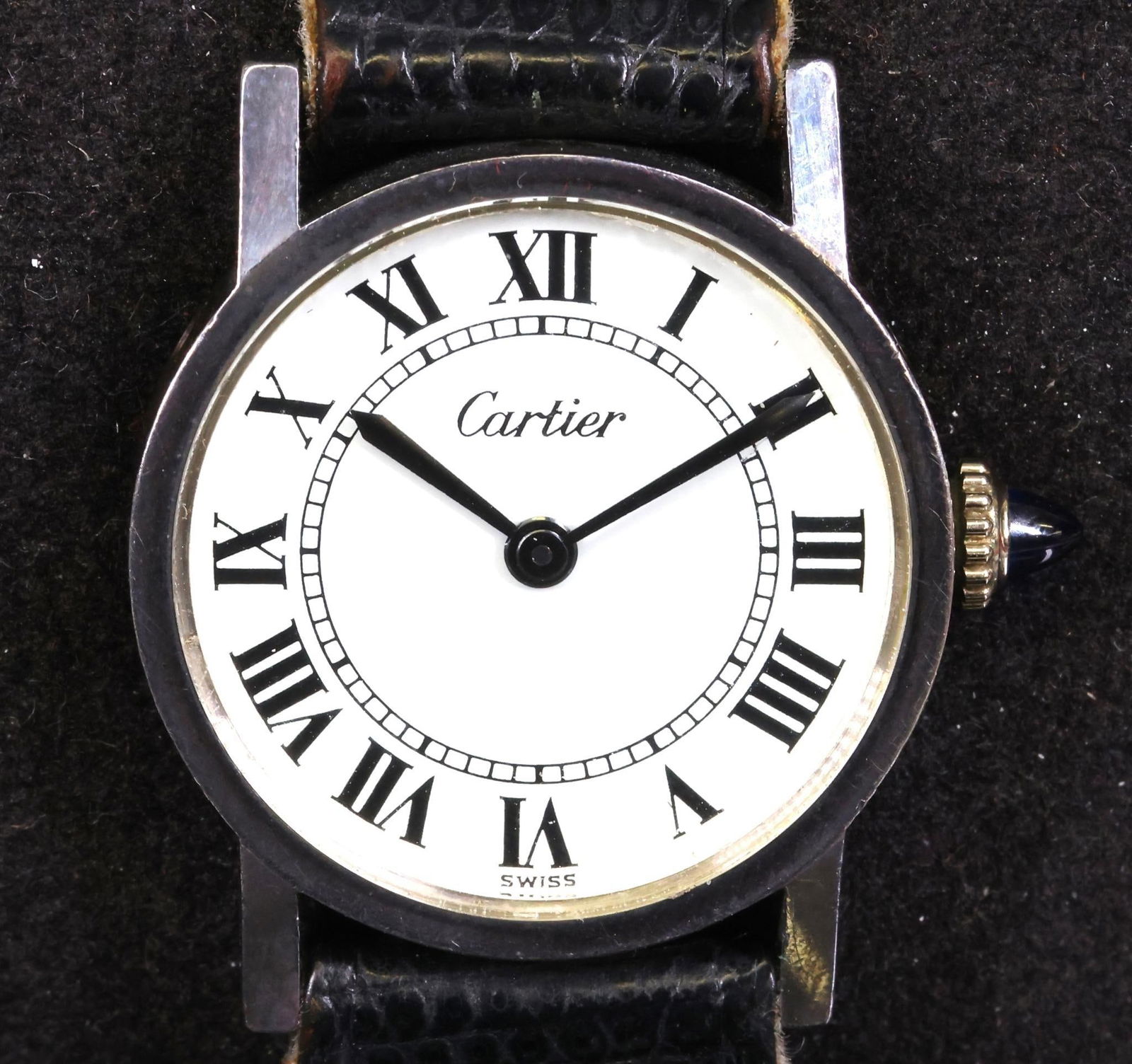 Cartier Sterling Silver Wristwatch: Cartier ladies wristwatch featuring a sterling silver round case with a 28 mm case, including crown and a slim 6mm profile. The silver bezel complements the white dial with Roman numeral markers. Swis