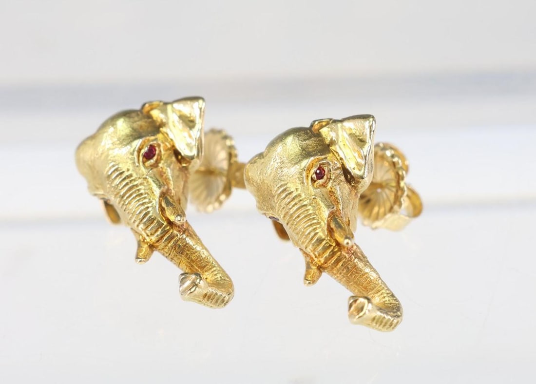 18k Elephant Earrings: 18k yellow gold elephant earrings with ruby accents for the eyes. Measuring 1" in size, 11.2 dwt.