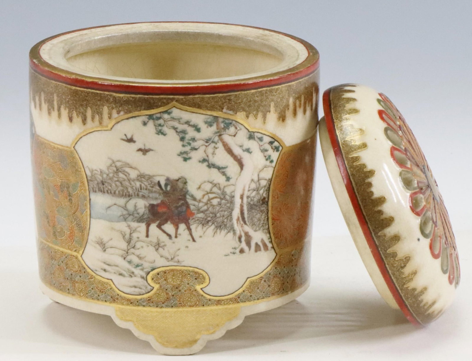 Hododa Japanese Satsuma Pottery Censer: Meiji era Satsuma censer or koro decorated with panels in the form of scrolls depicting various scenes of warriors and scholarly women, surrounded by floral and fan motifs, below a goldstone drip glaz