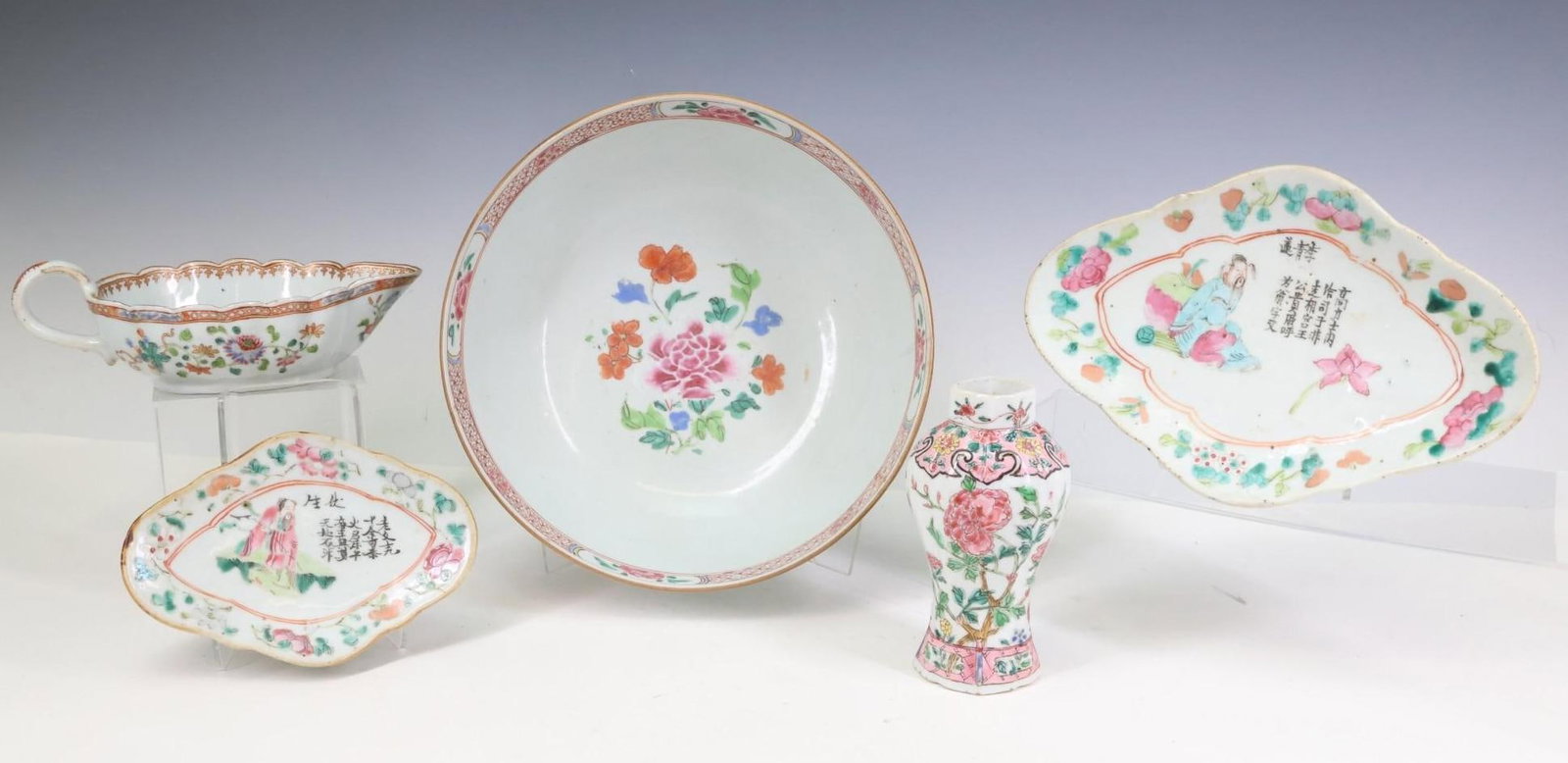Chinese Famille Rose Porcelain Wares: Qing era porcelain tablewares, including a serving bowl decorated with flowers and a sauce boat decorated with phoenixes and flowers, graduated lozenge form footed dishes with depictions of historical