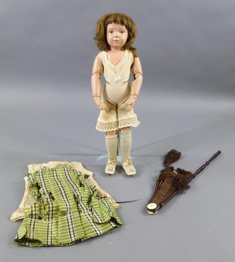 SCHOENHUT.: LOT. 16" Model No. 301 Schoenhut doll. She is marked with incised mark on back of torso. Blue intaglio eyes. Brown mohair wig may not be original. Dressed in factory ORIGINAL union suit (discolored) a