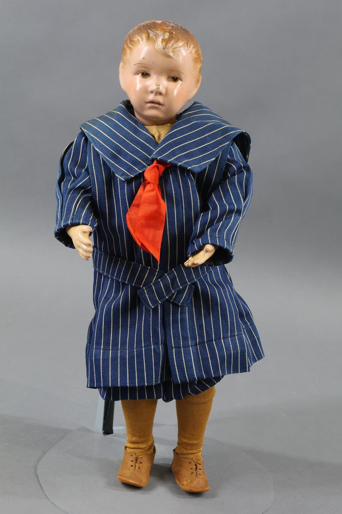 SCHOENHUT.: 16" Model No. 204 Schoenhut doll with carved hair. Incised mark on back of torso. Brown intaglio eyes. Dressed in antique navy/white striped Galatea Russian 2 pc. suit. Vintage beige linen under rompe