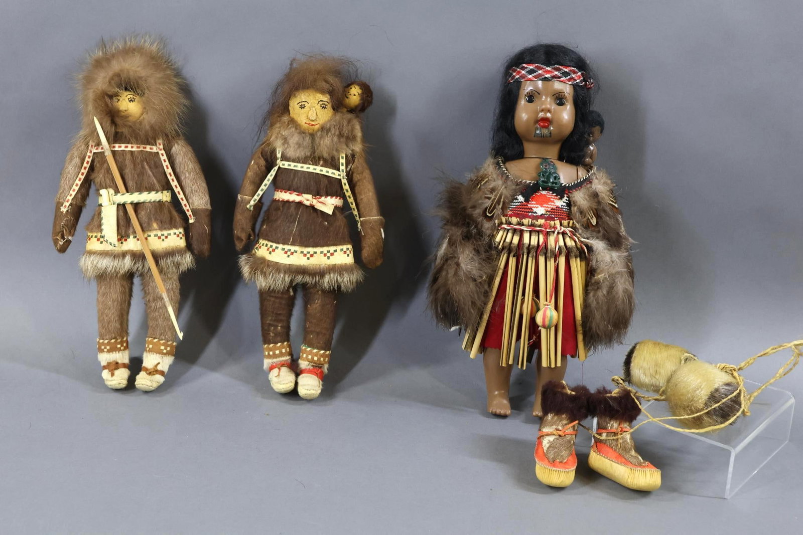 ALASKA/NEW GUINEA DOLLS.: LOT of (3) dolls. ALASKA - Pair of 11 1/2" leather dolls Male and Female with child. Both dolls have embroidered features, fur hair. They are dressed in seal skin clothing with decorated leather. Both