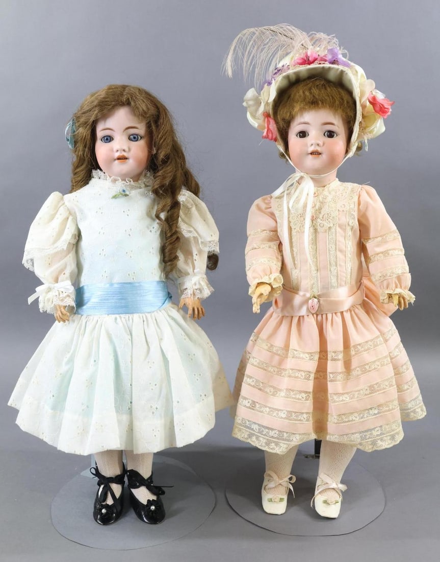 GERMAN BISQUE DOLLS.: Pair of SIMON HALBIG 550 sister dolls. Both dolls have sleep eyes, open mouths, brown wigs, pierced ears, papier mache ball jointed bodies and are dressed in newer/vintage clothing. Doll 1) 21" with b