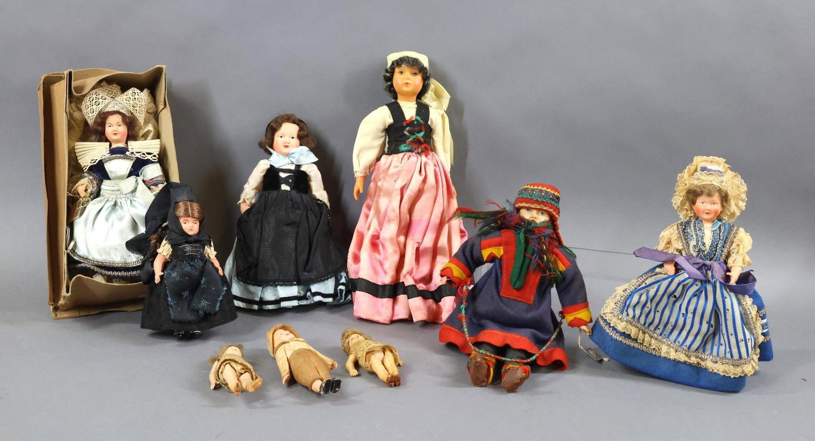 CELLULOID DOLLS.: LOT of (9) dolls. (6) Representing other countries. 5 1/2"-11". Dolls of Brittany dressed by LeMinor. (1) Boxed doll . Hang tag reads: Au Bon Marche, PARIS. Other Provincial French dolls. (1) Turtle m