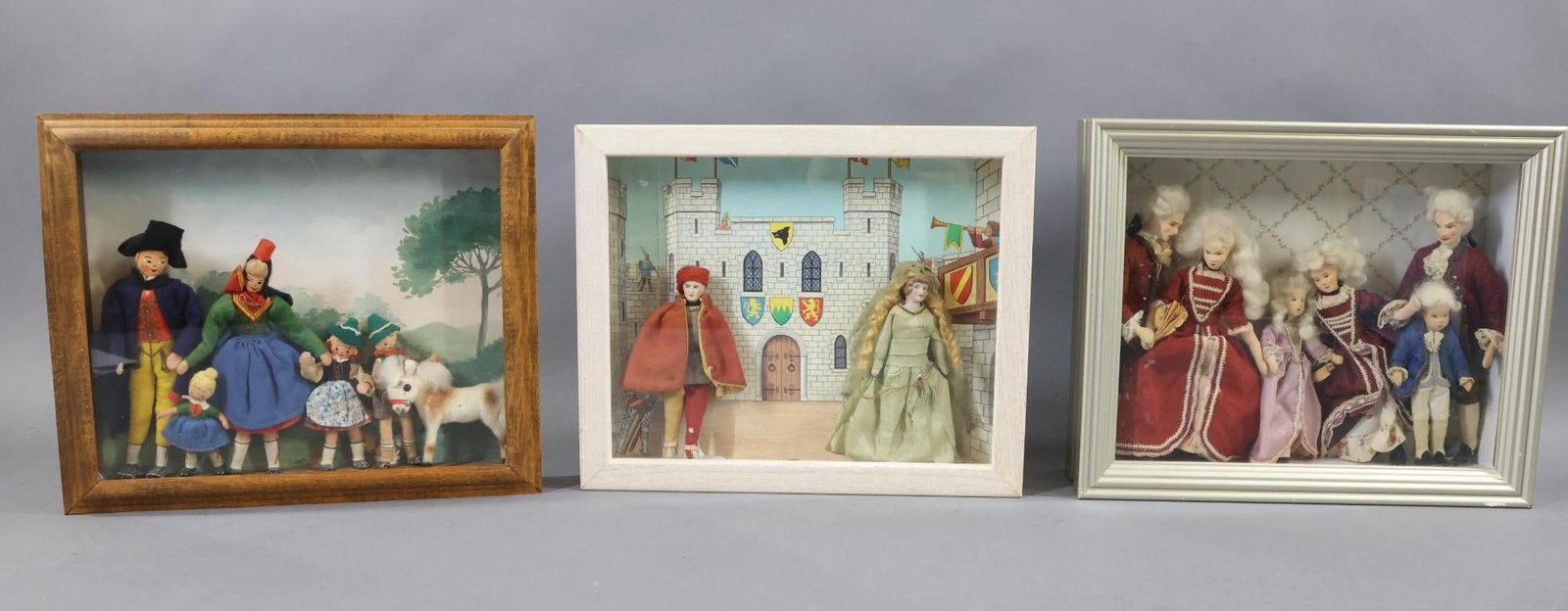MINIATURES.: LOT of (3) Shadow boxes. Each one of these boxes contains miniature antique dolls. Box 1) pair of 4 1/2", 5" German bisque head doll house dolls. Male and Female in costume. They are against a picture