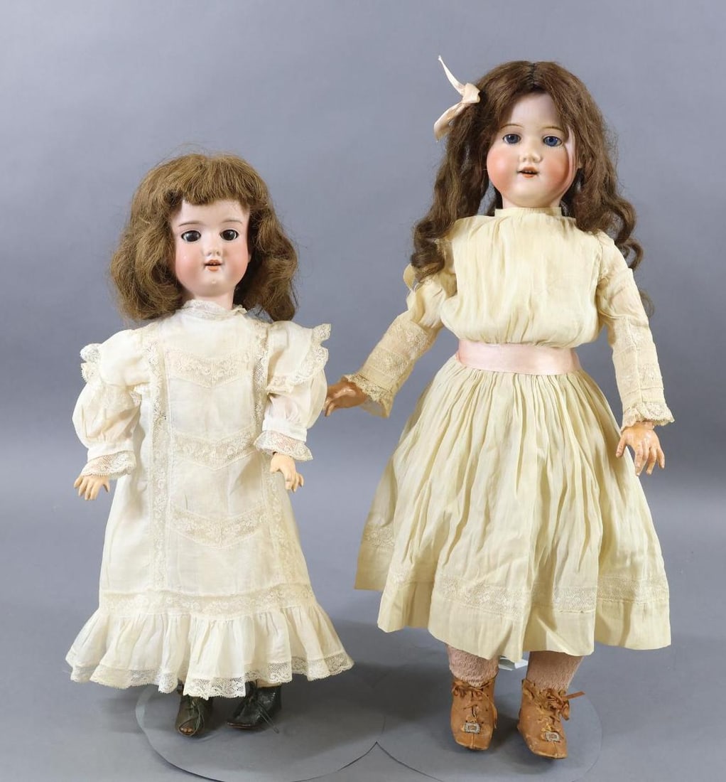 ANTIQUE BISQUE DOLLS.: Pair of dolls. Both dolls have sleep eyes, open mouths, brown HH wigs, papier mache jointed bodies. Doll 1) 20" M.B. JAPAN 5 with blue eyes. Long curly wig. Dressed in all antique cotton clothing: dre