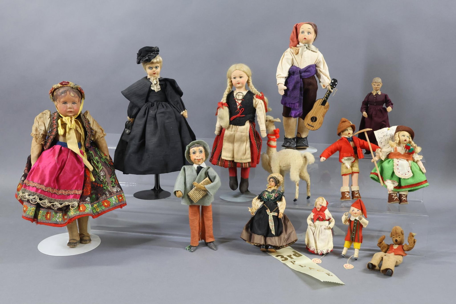 DOLLS REPRESENTING FOREIGN COUNTRIES/OTHER.: LOT of (12) dolls. 4 1/2" - 12". Italy - tagged TIROLO Male and Female. Male with guitar. GERMANY - tagged Male and Female with cloth heads, metal hands and feet. Tags read HEDE B.O. GERMANY - "Kruse"