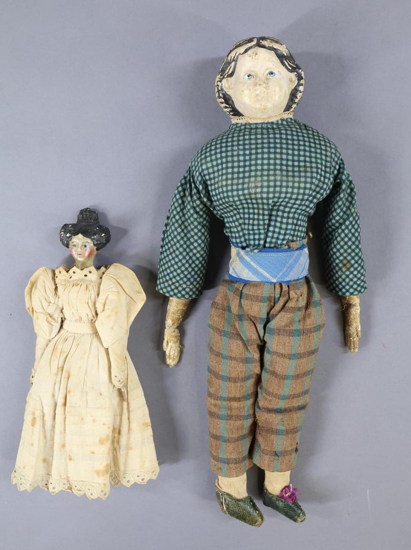 PAPIER MACHE.: Pair of dolls. Doll 1) 9 1/2" "Milliner's Model" with black side curls, Apollo knot style hair. Painted blue eyes, original kid body, wooden arms and legs. Painted gold shoes. Antique cotton clothing.