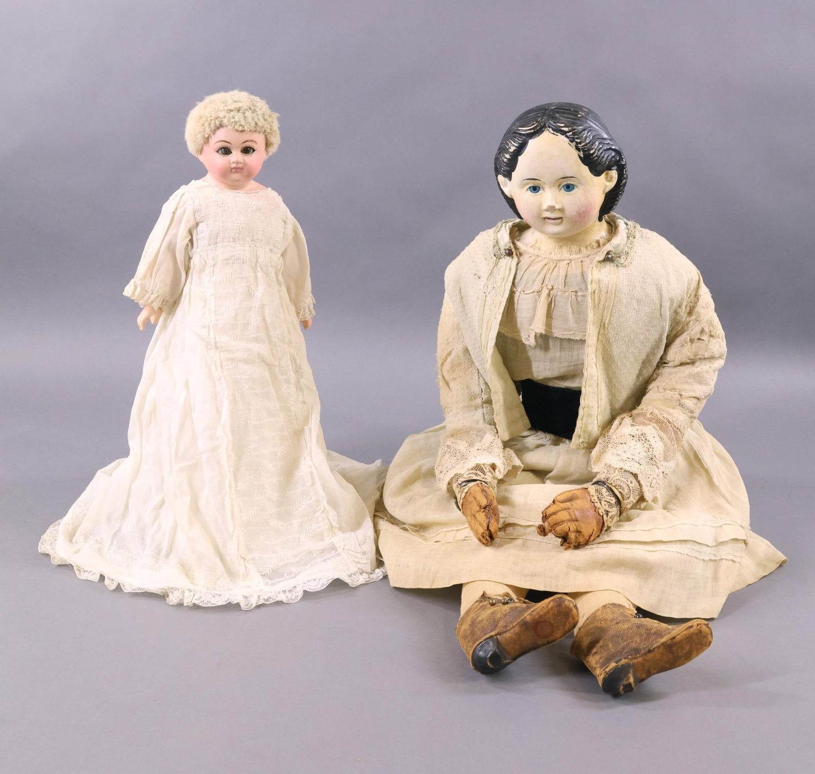 PAPIER MACHE.: Pair of dolls. Doll 1) 28" Greiner's Patent Heads No. 10, Pat'd March 30, 58". Cloth body with brown leather arms, sewn down fingers. Painted black hair, blue eyes. Dressed in antique white cotton clo