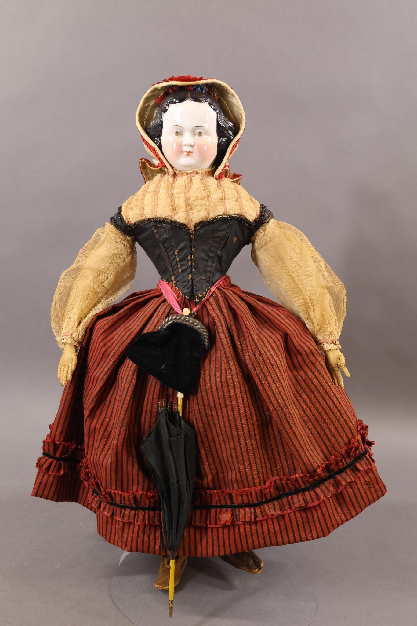 CHINA, PARIAN DOLLS.: 20" (1870's?) China shoulder head doll with painted BROWN eyes. Black center part hair with curls around sides and back. Faint pink lustre and cheeks. Cloth body with tan leather arms, individual fing