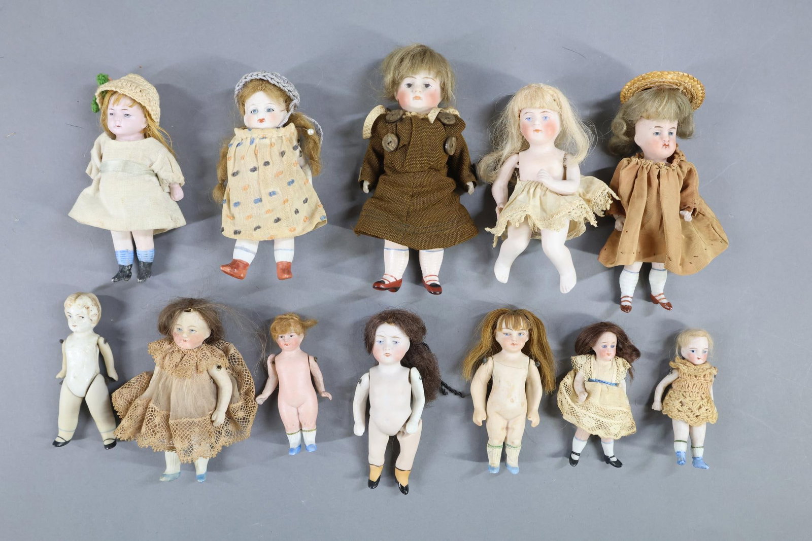 ALL BISQUE.: LOT of (12) Dolls with painted eyes. 3 1/4" - 5 1/2". Strung and wire strung. All but (1) have painted shoes and are wigged. Most are dressed. Condition: dolls may need restringing. Parts may have bee