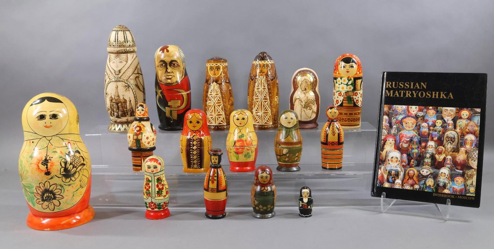 NOVELTY DOLLS/TOYS.: LOT of (16) wooden Russian/Ukrainian Matryoshkas, Book. Matryoshkas - painted, carved. Some are signed by the artist. Some have the location of where they were made. Religiously themed, inc. a Nun. Mo