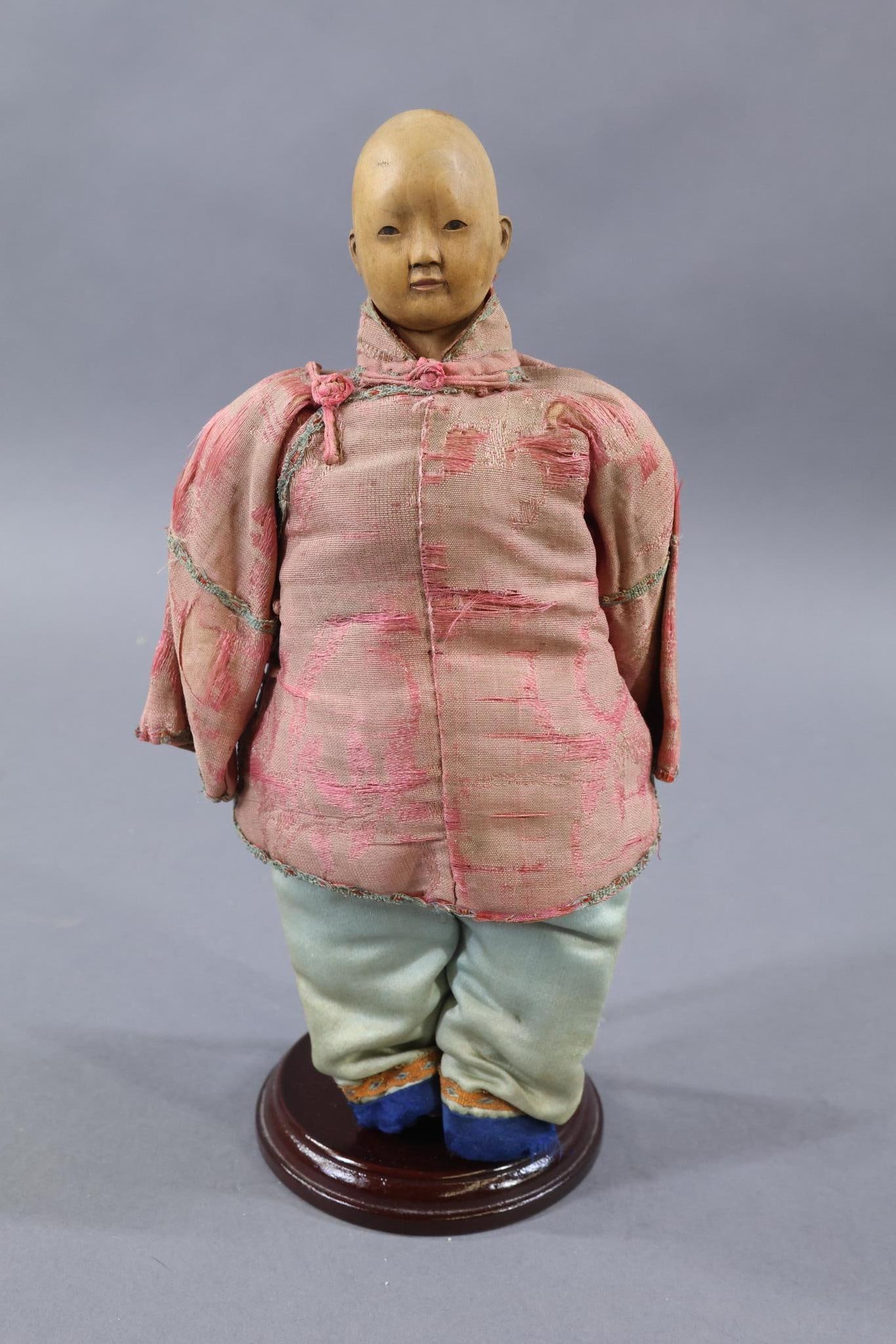 DOOR OF HOPE.: 9" "Young Boy in Silk" Doll. He has a painted pate but no queue. He may be missing his rice bowl hat. Stand. Condition: age loss, discoloration on silk clothing. This lot is being sold AS IS.