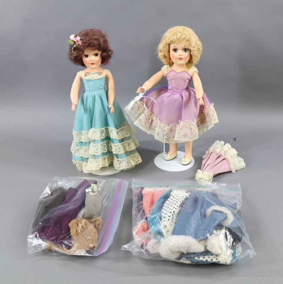 1950's-1960's DOLLS.: MARY HOYER. LOT. Pair of 14" Dolls and additional tagged clothing. Doll 1) dark henna mohair wig with brown eyes. Dressed in tagged tulle over turquoise gown (loss on tulle). Black panties, ivory oilc