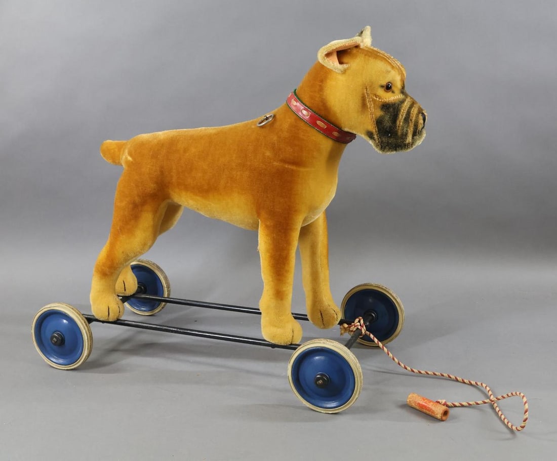 VINTAGE STEIFF.: VINTAGE STEIFF 1958 "Riding Sarras Boxer". 20" T x 21" L. Brown/black mohair with brown glass eyes. Dog is mounted on an iron frame, pull cord voice, standing on disc wheels with rubber tires. Conditi
