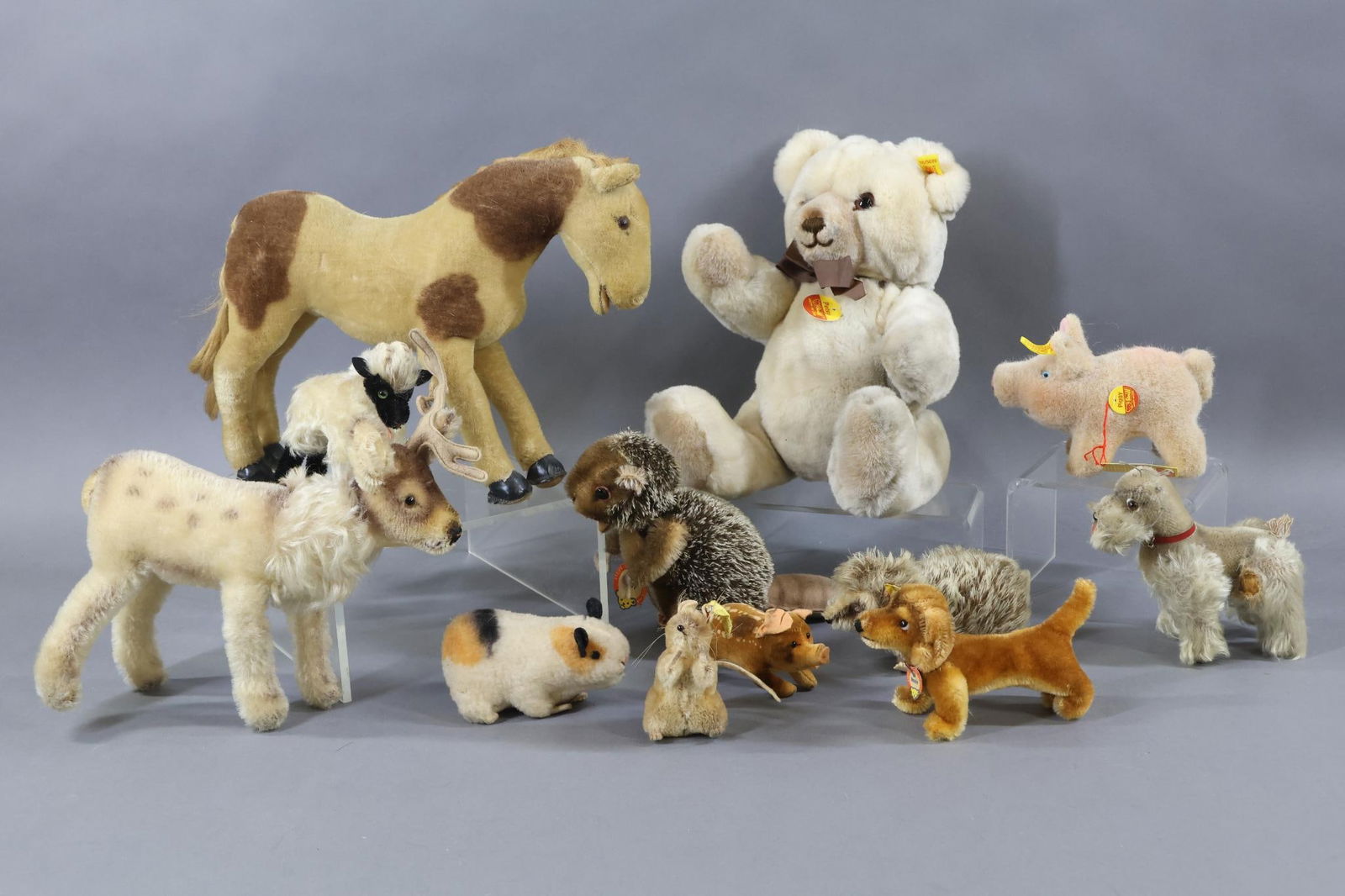VINTAGE STEIFF.: LOT of (9) Vintage animals and (3) plush animals. Vintage - (8) Mohair: Unmarked 11" "Pony", amber glass eyes, cloth tag reads: Made in US Zone Germany. 5 1/2" Gray "Schnauzer", glass eyes, original c