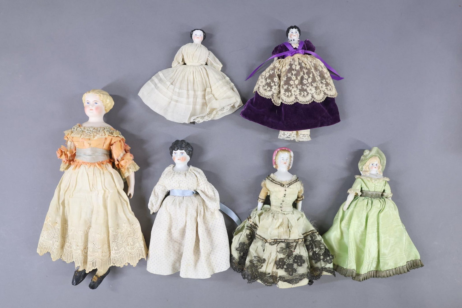 CHINA, PARIAN , BISQUE DOLLS.: LOT of (6) shoulder head dolls. China - (4) dolls. (3) With black center part hair, cloth bodies, china/parian lower limbs. Dressed in antique/vintage clothing. 5 1/2" (Shoulder plate repair). 6 1/2" 