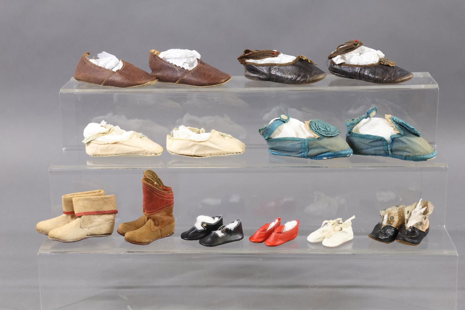 ACCESSORIES, SUPPLIES.: LOT of antique shoes. Leather, cloth, oilcloth. Leather - 1 1/2" Red. 1 1/2" White. 2" Black. 2 1/4" Brown boots. 2 3/4" Tan boots (marked Bazar Brasileiro). 4 1/4" Brown slip on shoes. 4 1/4" Brown w