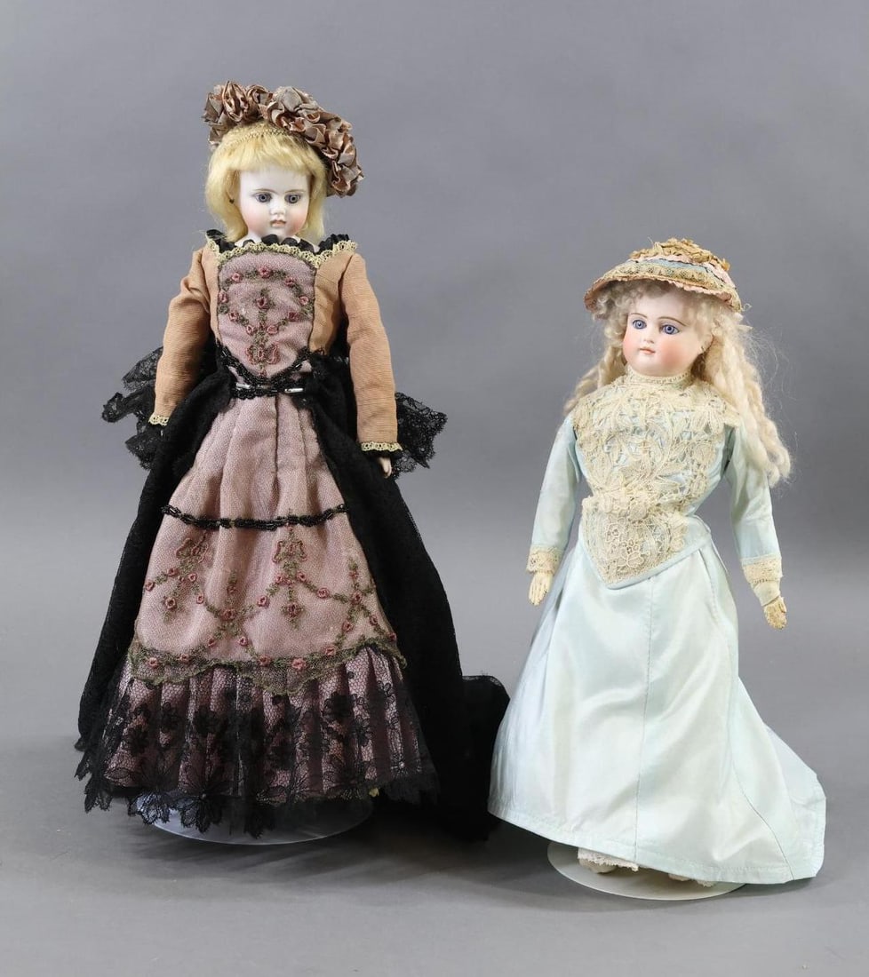 GERMAN BISQUE DOLLS - CLOSED MOUTH.: Pair of dolls. Both dolls have stationary blue eyes, pierced ears, blonde mohair wigs, leather bodies. They are dressed in vintage clothing. Doll 1) 13" Unmarked socket head on a bisque shoulder plate
