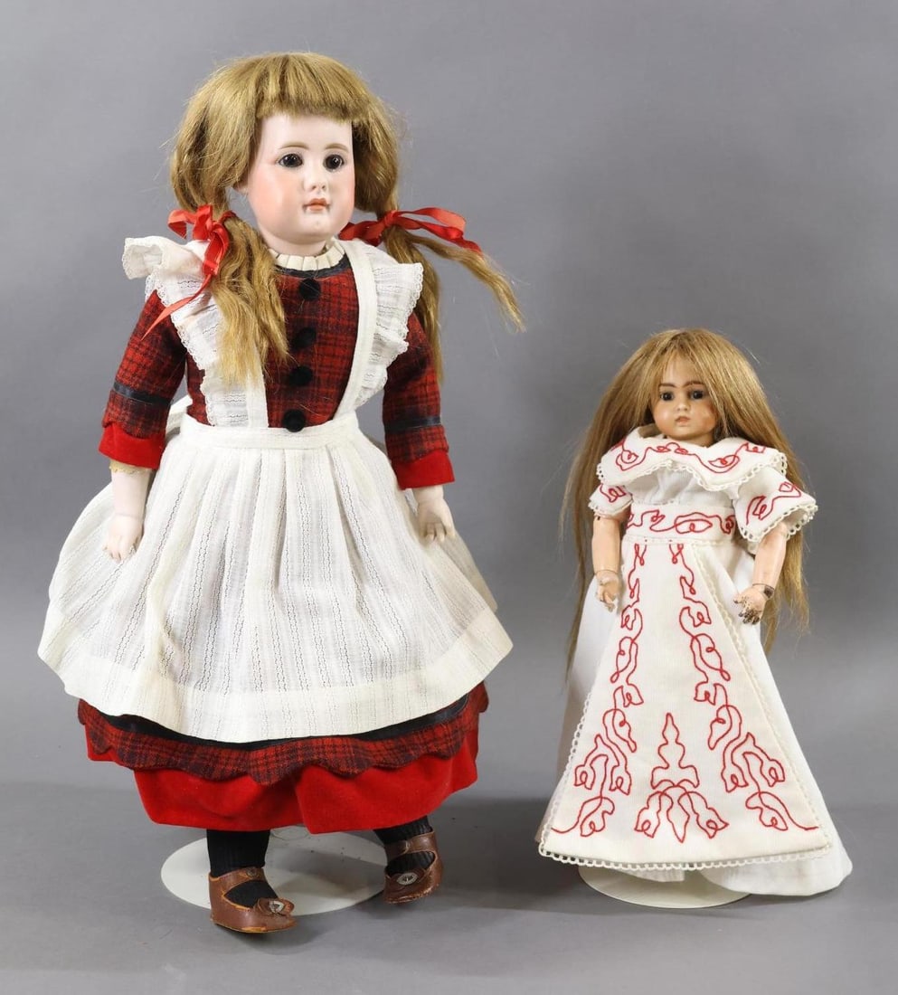 GERMAN BISQUE DOLLS - CLOSED MOUTH.: Pair of solid dome dolls. Both dolls have stationary eyes, brown HH wigs. They are dressed in vintage/antique clothing. Doll 1) 20" S 11 H 949 bisque socket head on a bisque shoulder plate. Brown eyes