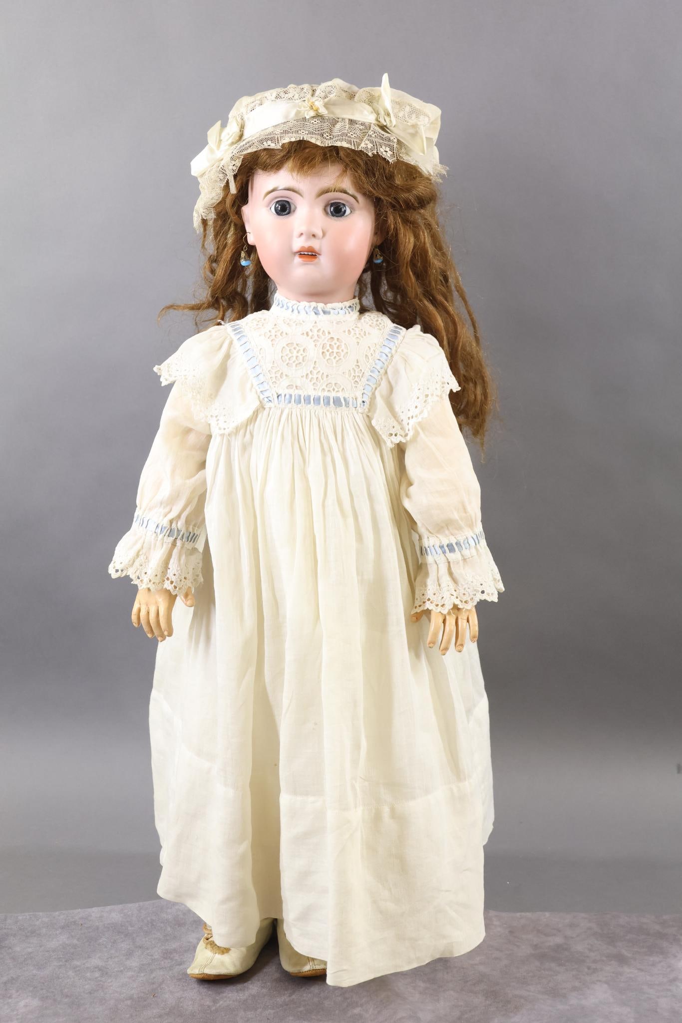 FRENCH BISQUE DOLLS.: 29" (Incised) "12". (JUMEAU). Blue paperweight eyes, open mouth, pierced ears, long brown HH wig, cork pate. Papier mache/wood fully jointed body, separate hands. Dressed in antique white cotton cloth