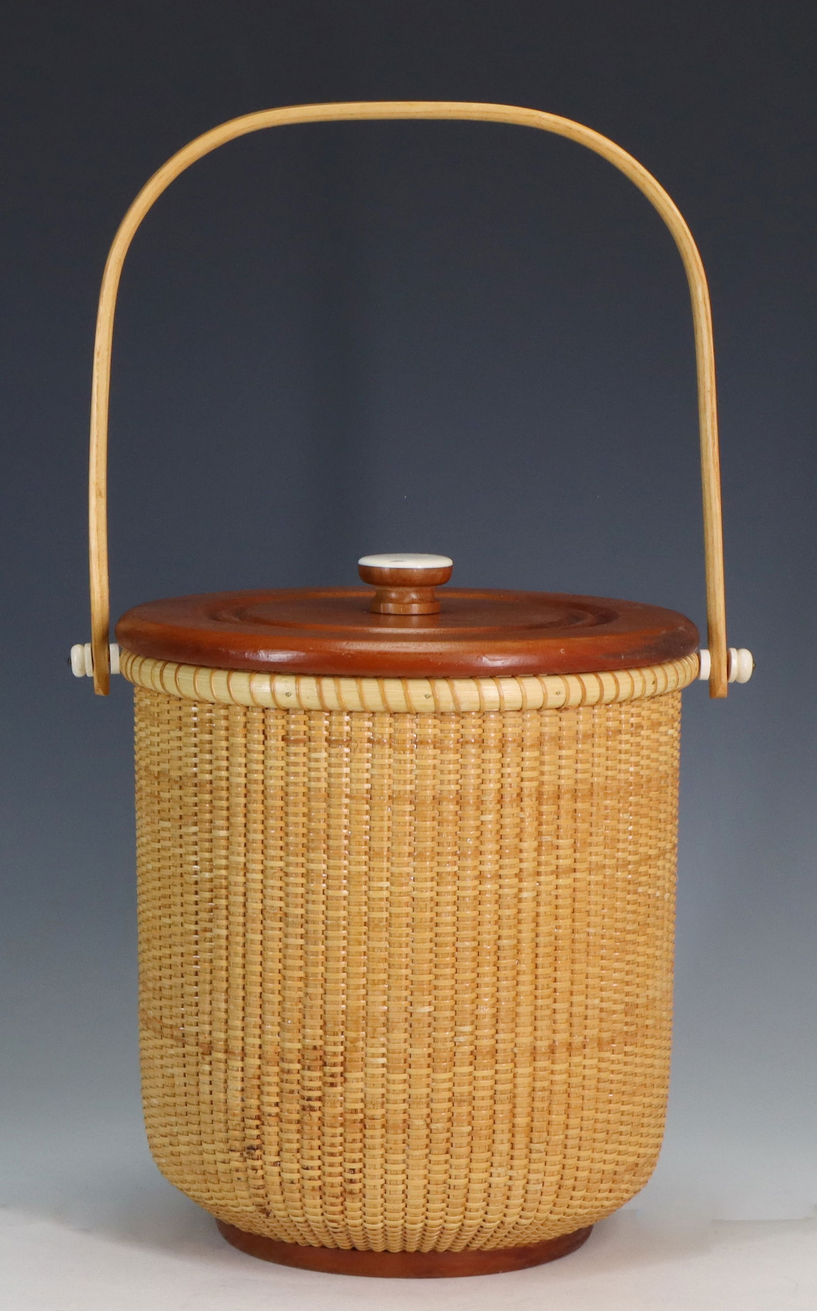 Terry Sylvia Nantucket Basket Ice Bucket: Lightship basket with a bail handle, mahogany top, and plastic interior lining, brand mark to the foot, also signed and dated December 25, 2000. 10"h x 9"w
