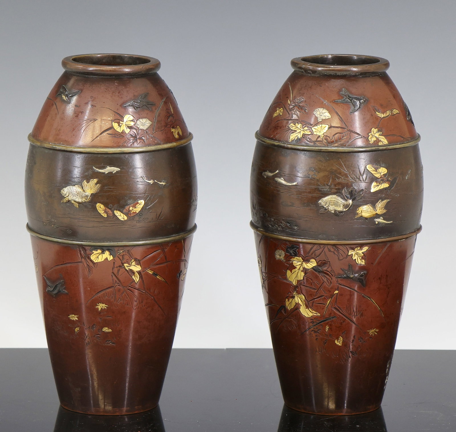 Miyabe Atsuyoshi Japanese Inlaid Bronze Vases: Meiji era pair of parcel-gilt bronze, shakudo, and silver vases with chased and zogan inlaid decoration, the raised band around the shoulders depicting a stream with fish and water plants, surrounded 