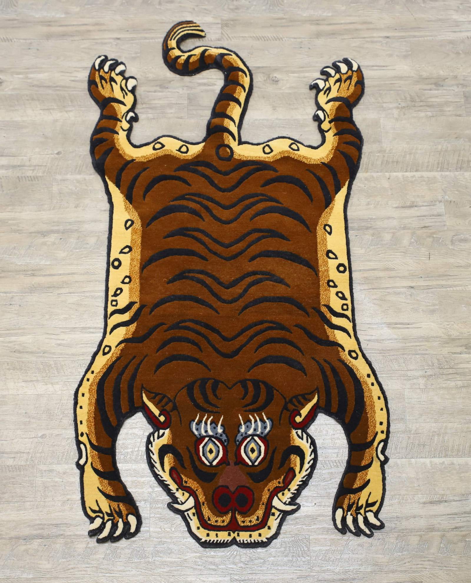 Tibetan Tiger Rug: Hand woven wool multi-colored tiger form pattern area rug with stripes, claws, and teeth. 3'w x 5'8"l