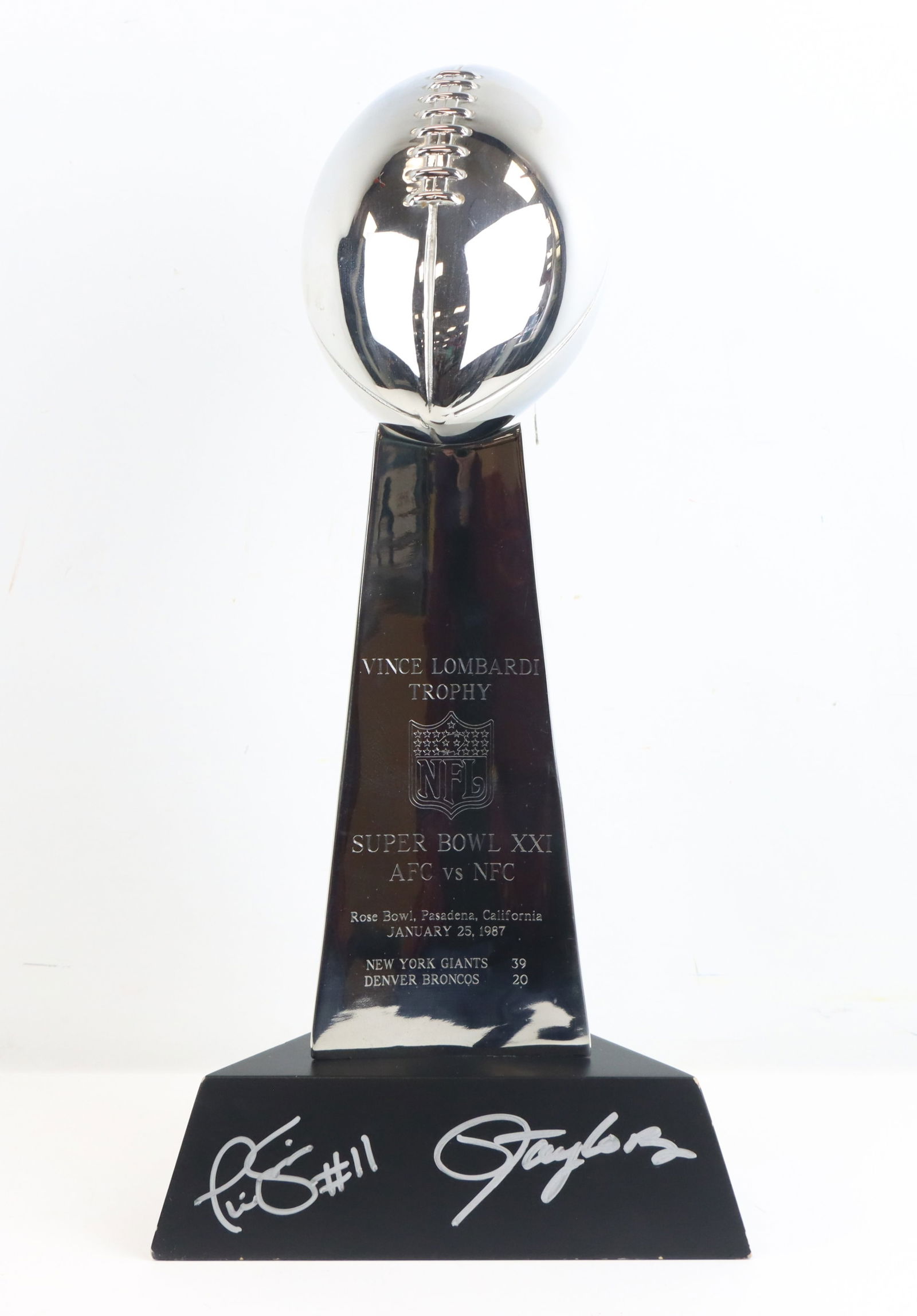 Phil Sims & Lawrence Taylor Signed Trophy: This Super Bowl XXI Vince Lombardi Trophy replica commemorates the New York Giants' 39-20 victory over the Denver Broncos at the Rose Bowl in Pasadena, California on January 25, 1987. The base feature