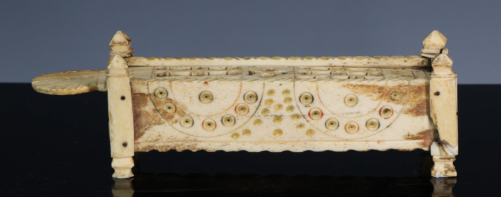 Napoleonic Prisoner of War Bone Games Box, 19th Century: 19th-century Napoleonic prisoner of war games box, carved from bone in the form of a four poster bed with turned finials and sliding lid. The box contains a set of bone dominoes with incised and pigme