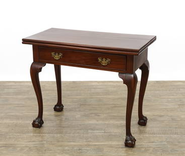 Centennial Chippendale Card Table: Chippendale mahogany card table with a hinged rectangular top with molded edge, over a single full-width drawer fitted with period-style brass batwing pulls. The table stands on four cabriole legs wit