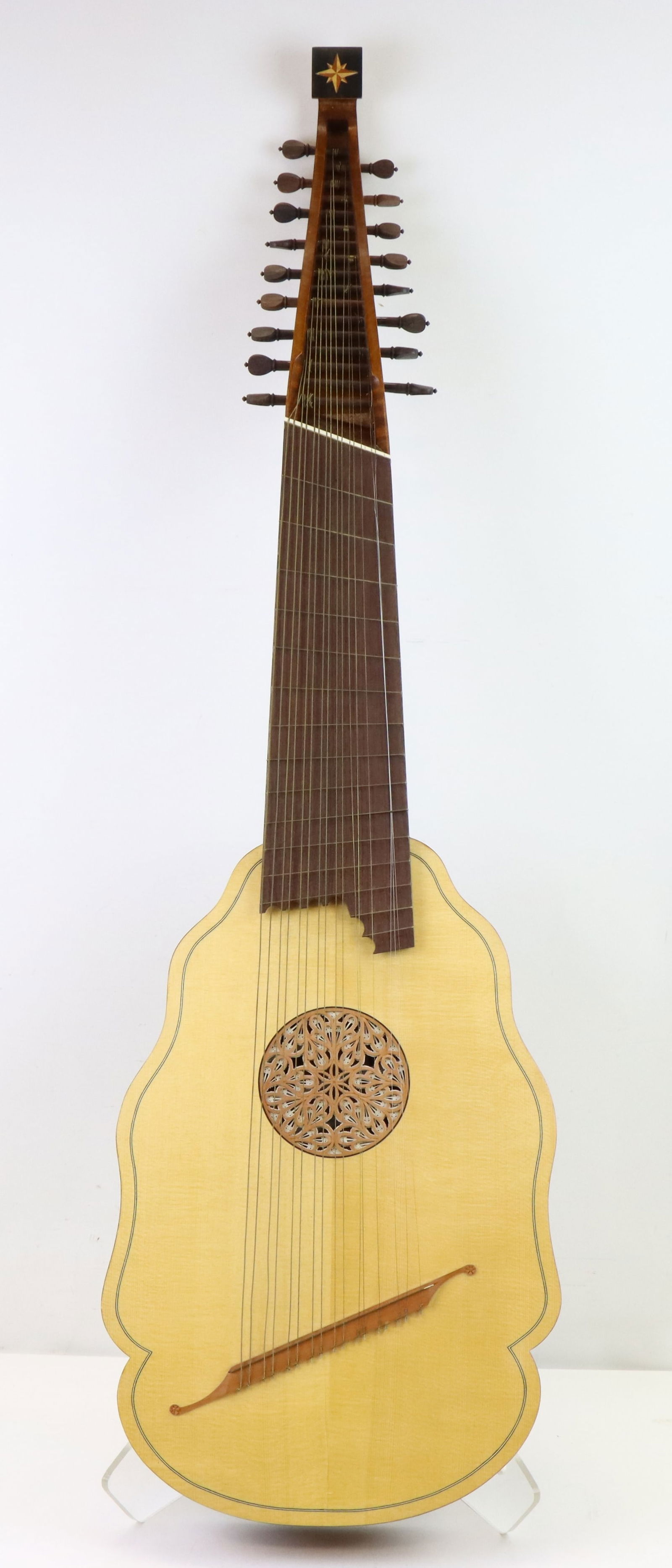 Baroque-Style Archlute with Decorative Rosette: Baroque-style archlute featuring a scalloped spruce top with an ornate carved wooden rosette. The back is crafted from alternating striped wood panels, likely flamed maple and ebony. Seventeen string