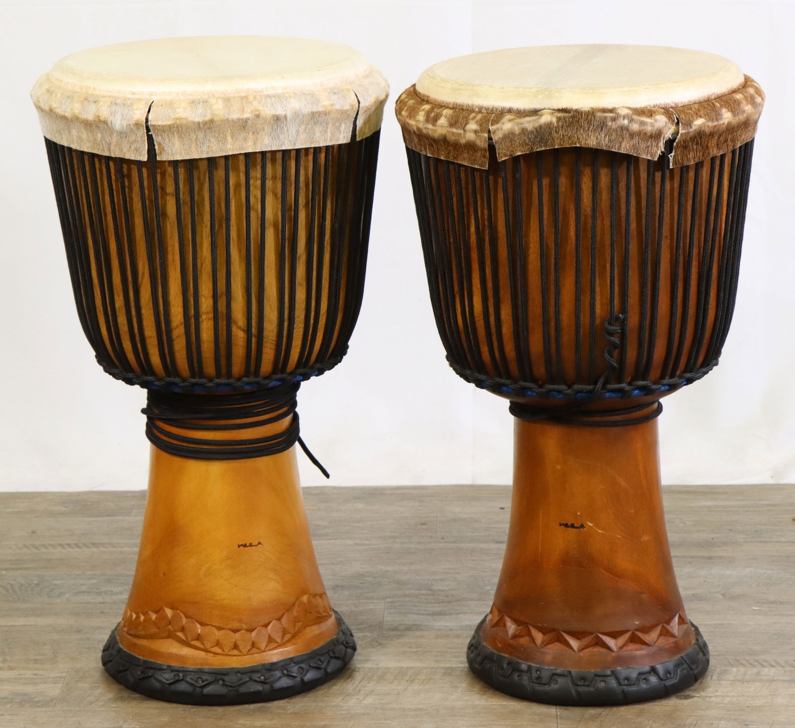 Pair Unlabelled Djembe Drums: Pair of Unlabelled Djembe Style Drums. Carved Wood in Good Used Condition. Edges of Heads Show 2 Minor Splits Each. Does Not Impact Head Tension or Playablity. Country of Orgin Unknown. 24.5"h x 14"di