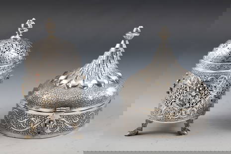 Indian Silver Boxes: Architectural form boxes from India with chased Arabesque decoration, including a footed box with openwork, handles, and removable cover, marked silver 925, and a box with hinged cover and latch, unma