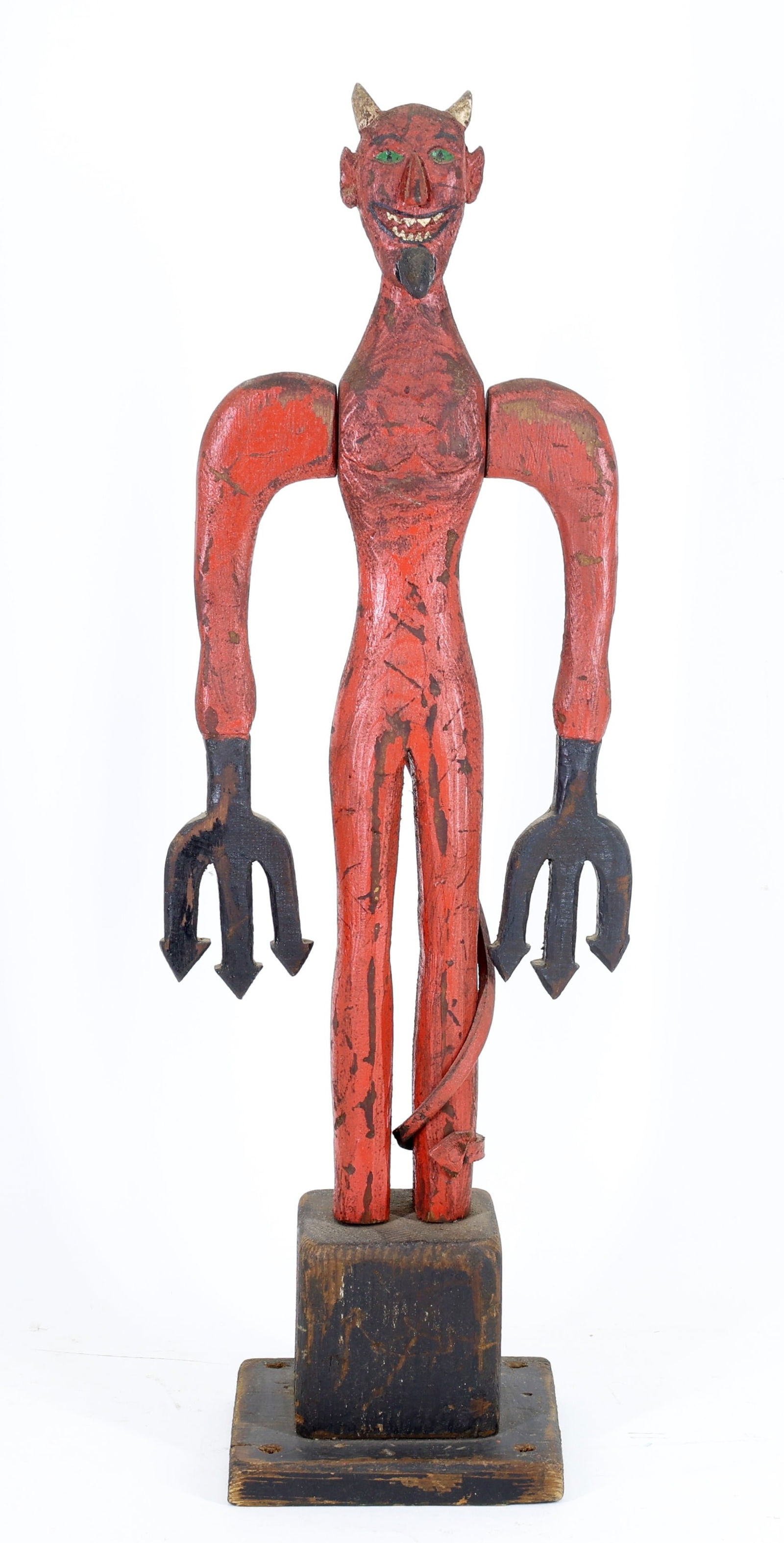 Folk Art Whirligig: Folk art painted wood whirligig of a red devil with tridents for hands and leather tail mounted on a square wooden base. 23.5"h x 8"w x 5.5"d.