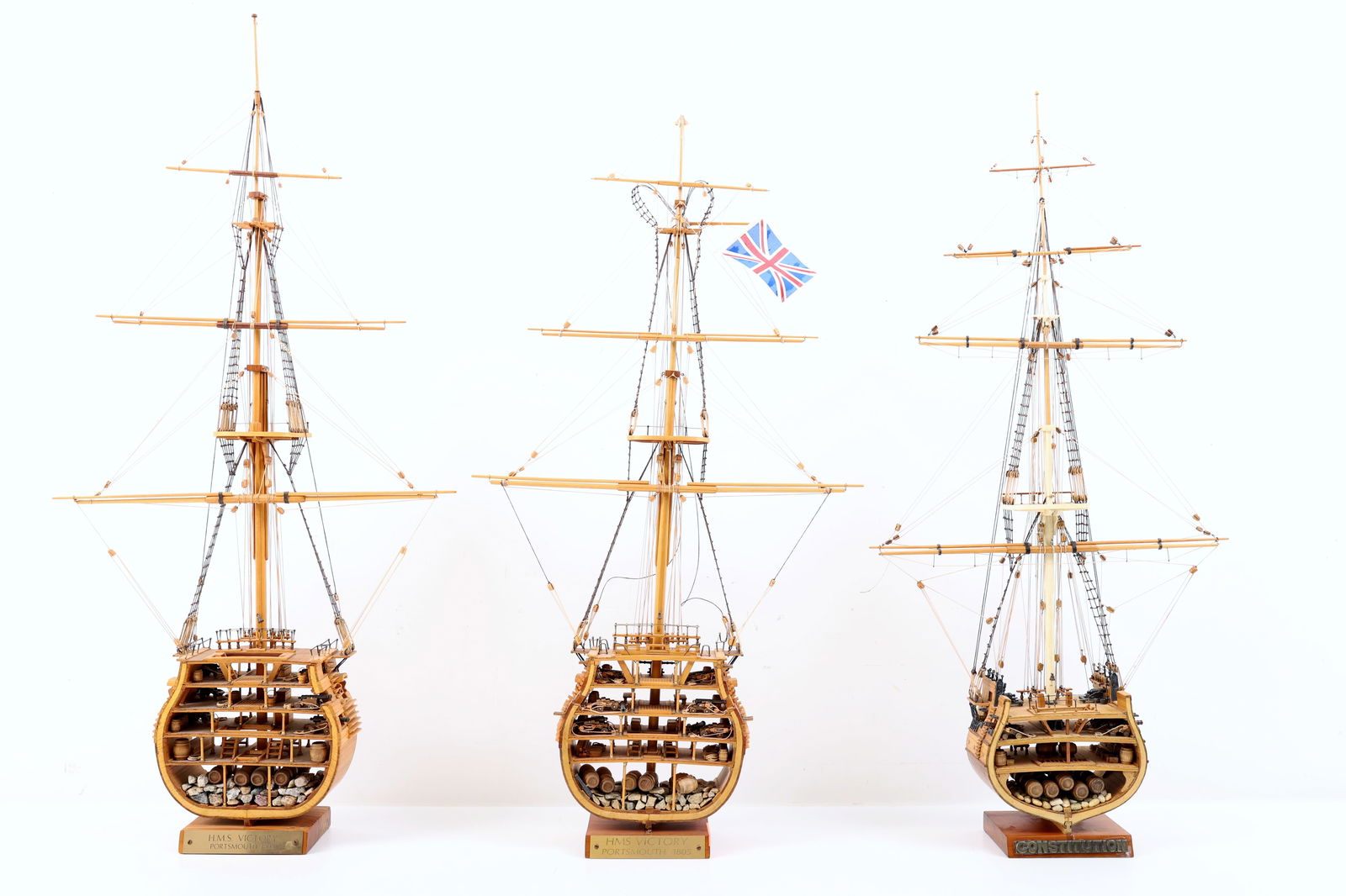 Wooden Sectional Ship Models: H.M.S. Victory and U.S.S. Constitution: Three wooden sectional ship models, built by Stephen M. Hutsko of Palermo, New Jersey, depicting cross sections of historical warships with visible interior construction, cannons, barrels, and ballast