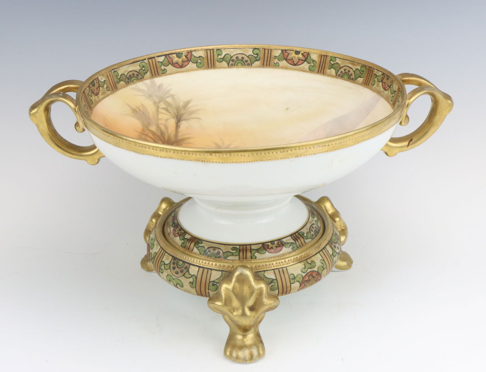 Nippon Porcelain Serving Bowl: Nippon porcelain serving bowl with footed stand, c. 1891-1921, hand painted Egyptian desert, decorative edging on both pieces, marked, bowl 4.5"h x 12"w x 9.25"d, 6.75"h on stand.