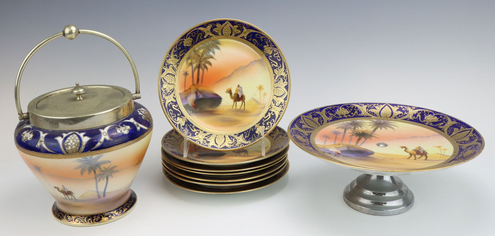 Noritake Porcelain: Noritake porcelain biscuit barrel with handle, 7 dessert plates and compote dish, all marked, hand painted, all Egyptian desert pattern, biscuit basket is 8.5"h x 6"dia.