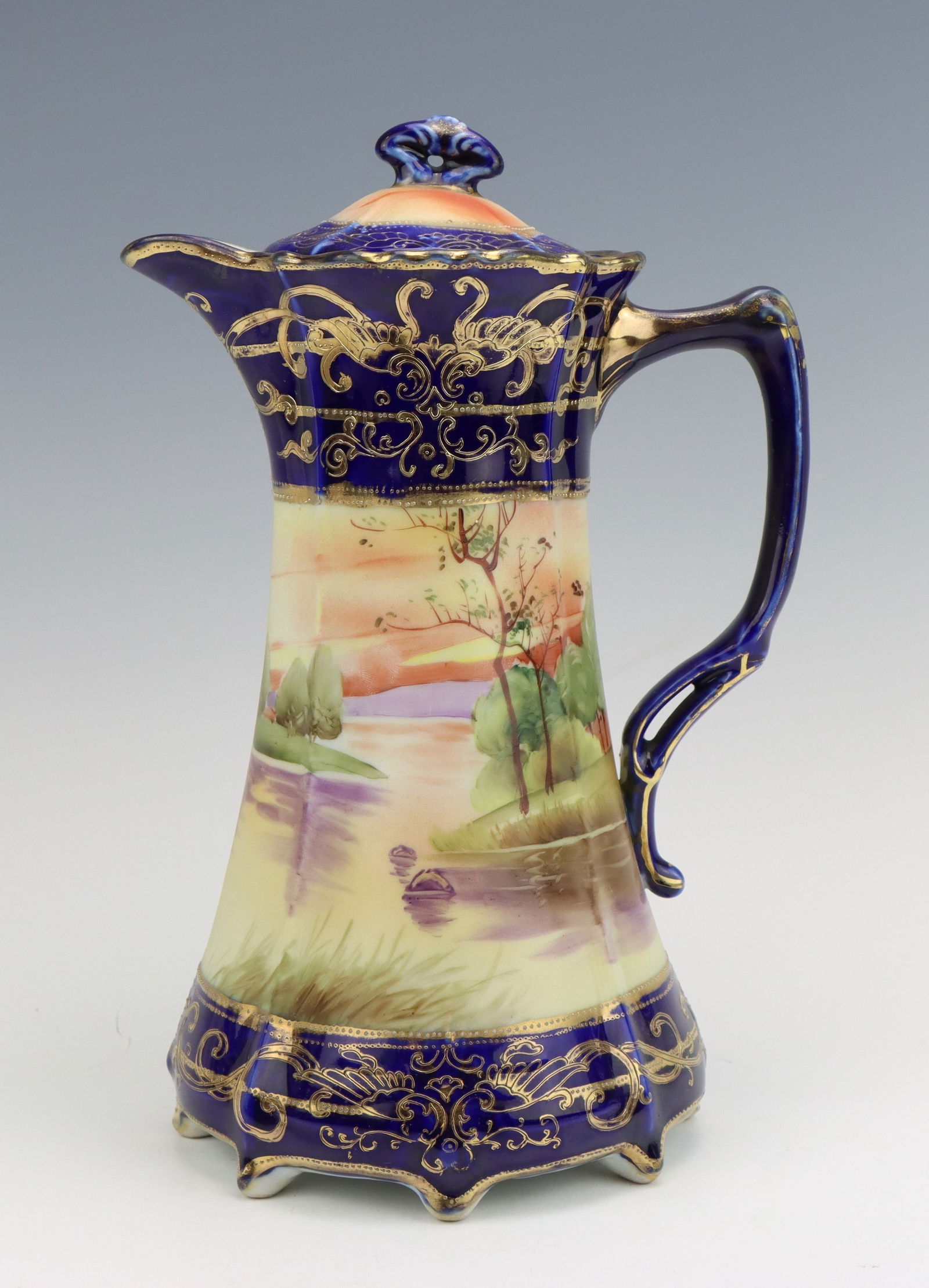 Nippon Teapot: Nippon porcelain teapot with lid, c. 1891-1921, hand painted riverside scene, cobalt with moriage decoration, marked, 10.75"h x 7"w x 5.5"d.